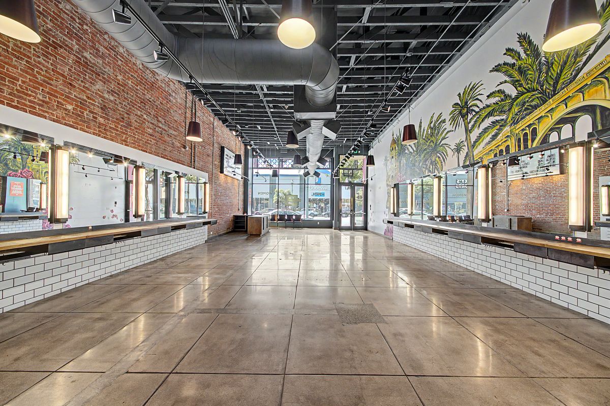 Suite 1 interior: polished concrete floor, exposed ceiling, brick and subway-tile walls, and a painted mural on the far wall.