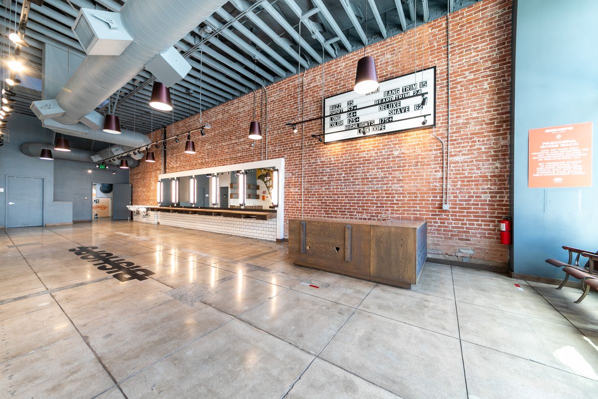Suite 1 interior: brick wall, wooden reception counter, and pendant lights.