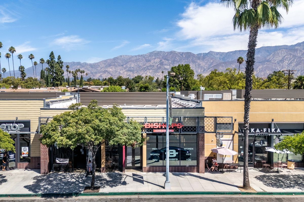 Storefronts in the main building along Colorado Boulevard under street trees, with Suite 1 in the middle of the row.